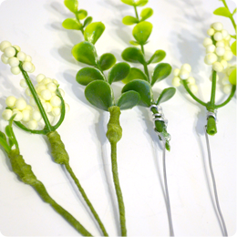4.將人造花的花朵和葉片，一朵一朵拆剪下來，花梗部份插上8cm長的鋁線，並以紙膠帶包覆鋁線到完全覆蓋。